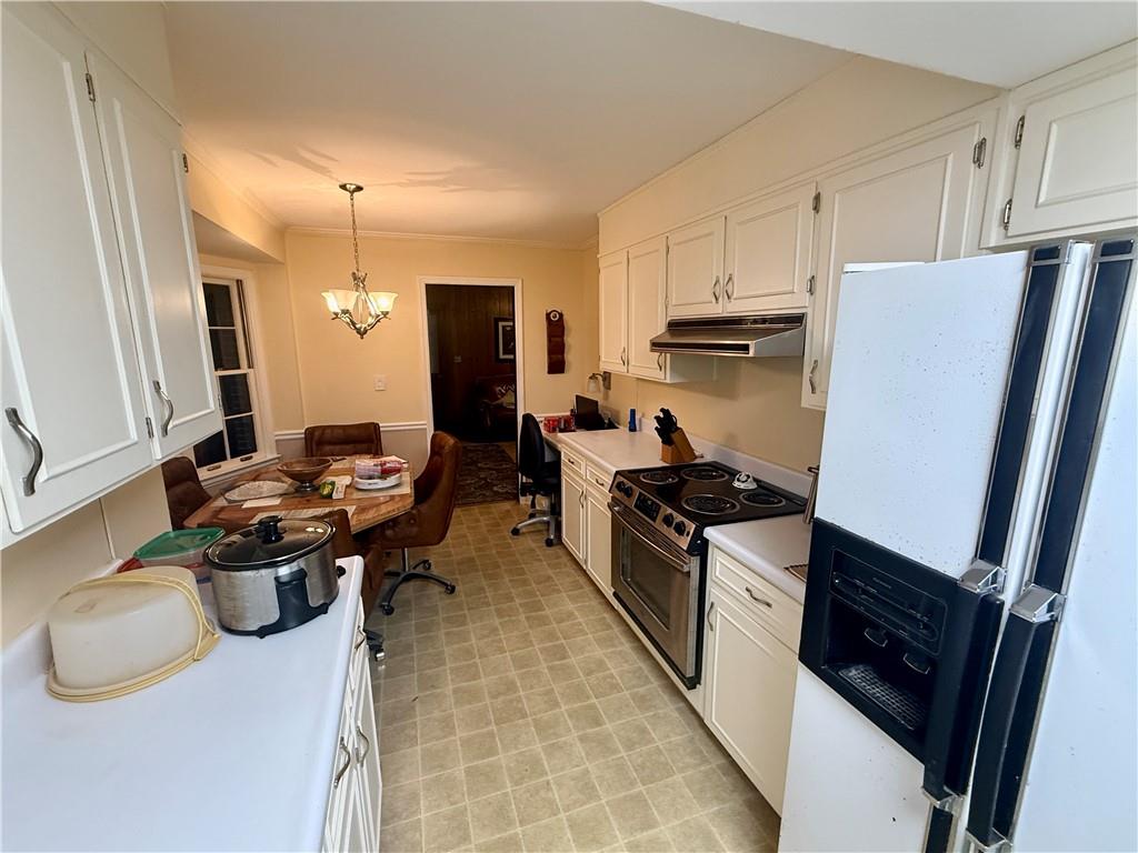 5705 Orly Terrace Atlanta, GA 30349 - Photo 14 of 42 a kitchen with stainless steel appliances a stove a sink dishwasher a refrigerator white cabinets and wooden floor