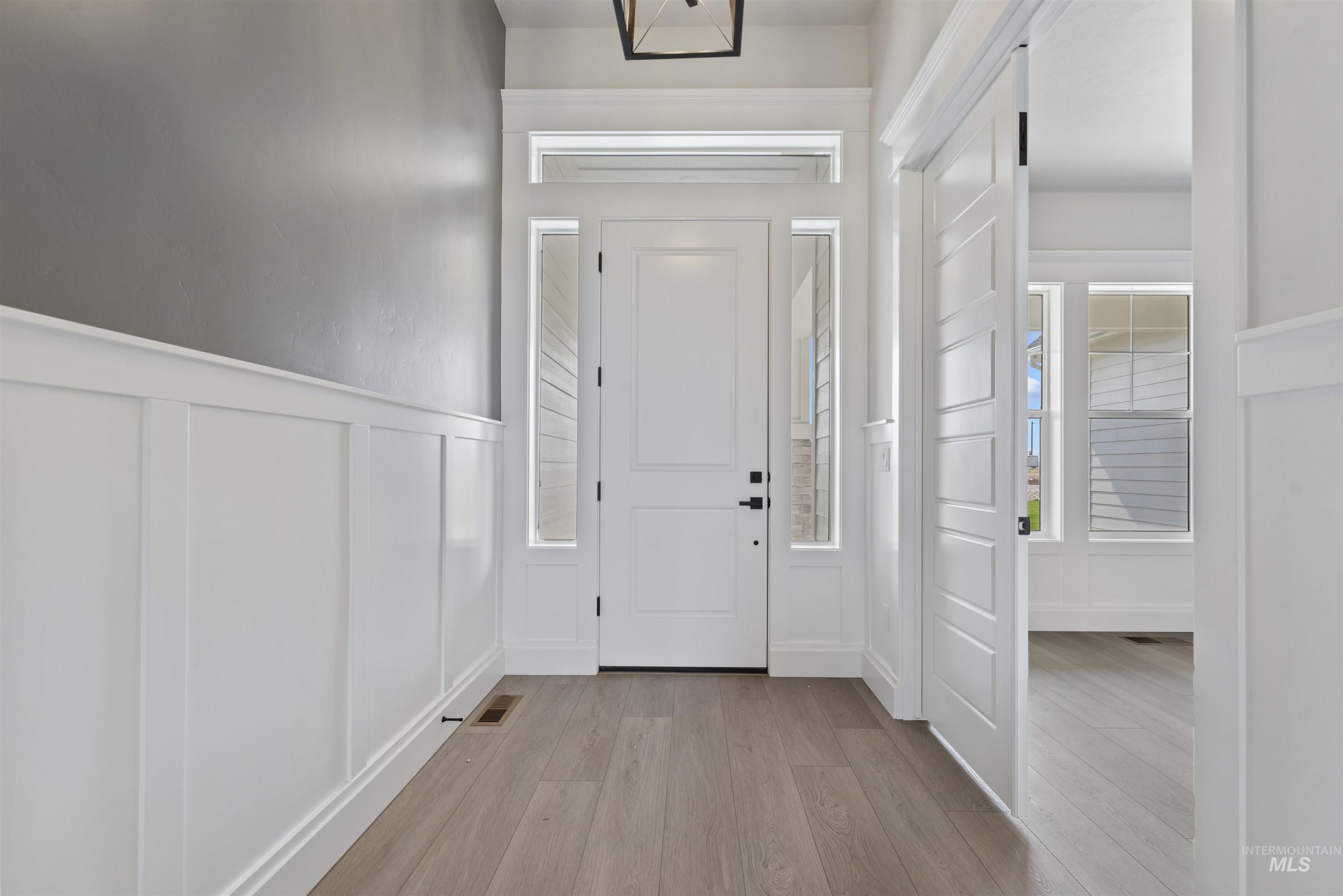 9283 Basin Kid Court Middleton, ID 83644 - Photo 10 of 21 Entryway featuring light wood finished floors, a decorative wall, and wainscoting