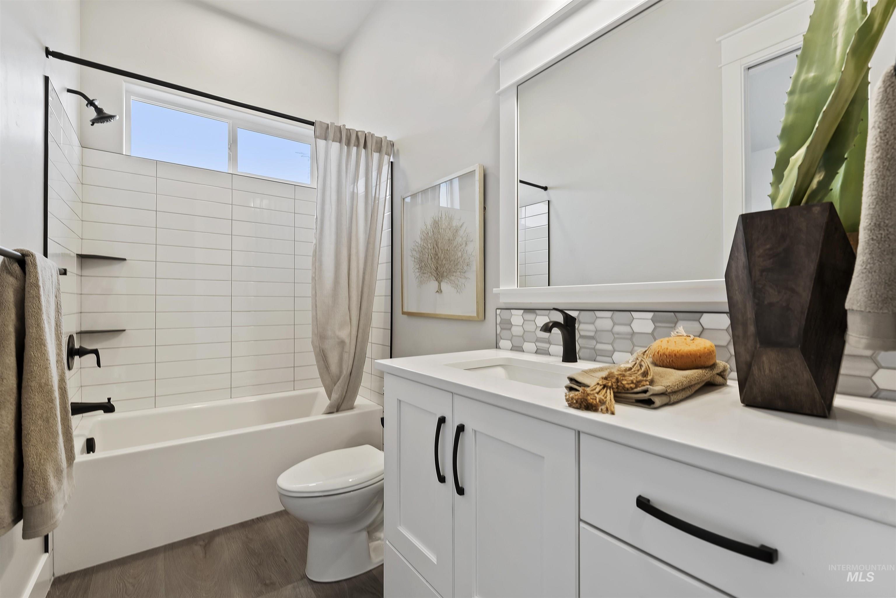 9283 Basin Kid Court Middleton, ID 83644 - Photo 17 of 21 Bathroom with vanity, shower / bath combo, backsplash, and dark wood-style flooring