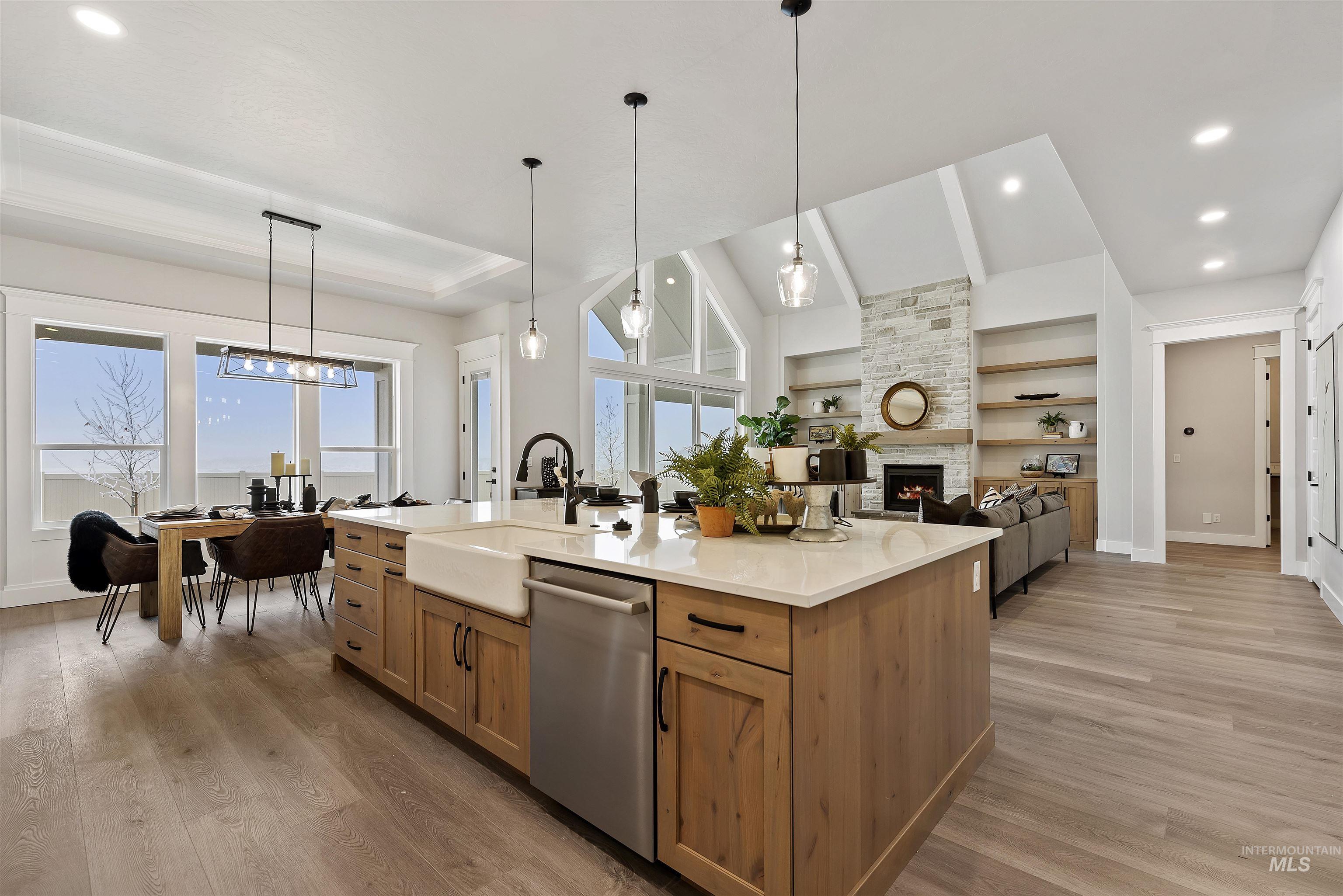 9283 Basin Kid Court Middleton, ID 83644 - Photo 20 of 21 Kitchen with open floor plan, dishwasher, a kitchen island with sink, light stone countertops, and light wood-type flooring