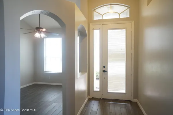 an empty room with wooden floor and mirror