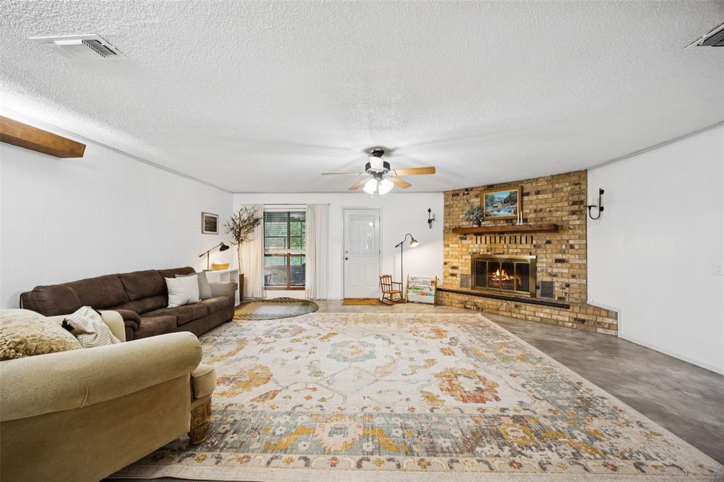 3569 Luella Road Sherman, TX 75090 - Photo 6 of 38 a living room with furniture a fireplace and a flat screen tv
