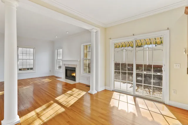 a view of a livingroom with wooden floor and a fireplace