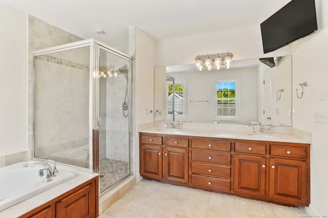 a spacious bathroom with a granite countertop sink mirror and a bathtub