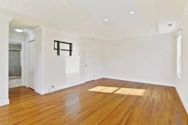 a view of empty room with wooden floor