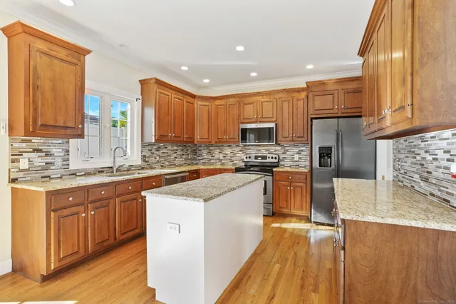 a kitchen with stainless steel appliances granite countertop a stove sink and cabinets