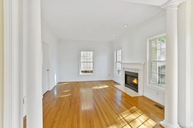 a view of empty room with a fireplace and wooden floor