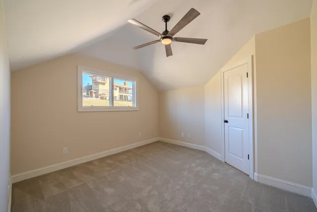 a view of an empty room with a ceiling fan and a window