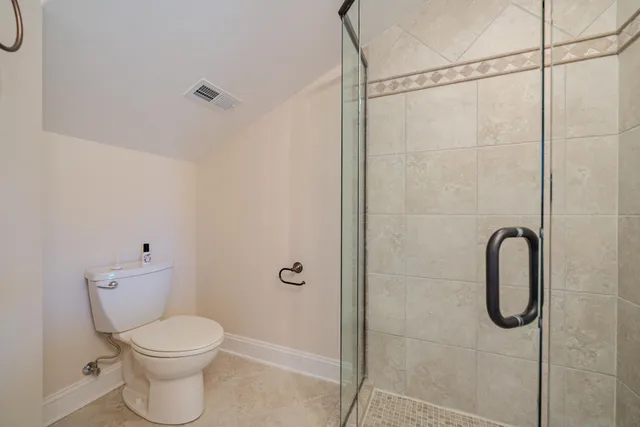 a bathroom with a toilet and a shower