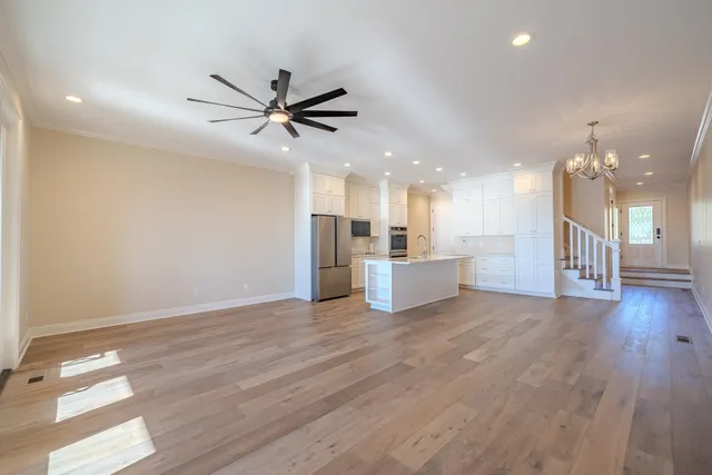 a view of a big room with wooden floor and a kitchen