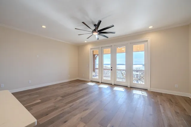 a view of an empty room with window and wooden floor