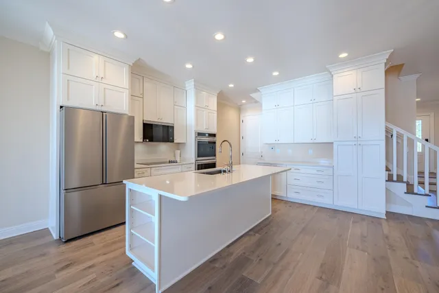 a large kitchen with stainless steel appliances a refrigerator and a stove top oven