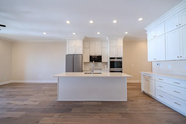 a view of kitchen with stainless steel appliances kitchen island sink and living room