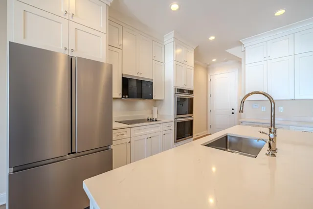 a kitchen with stainless steel appliances a refrigerator sink and microwave