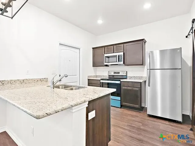 a kitchen with a refrigerator a microwave a sink and a stove