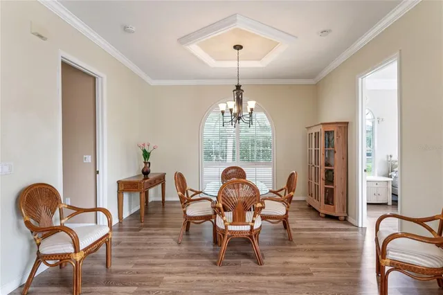a dining room with furniture a chandelier and wooden floor