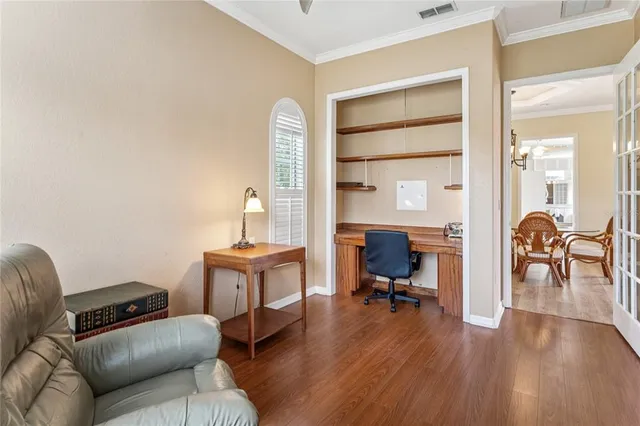 a view of a hallway with wooden floor table and chairs