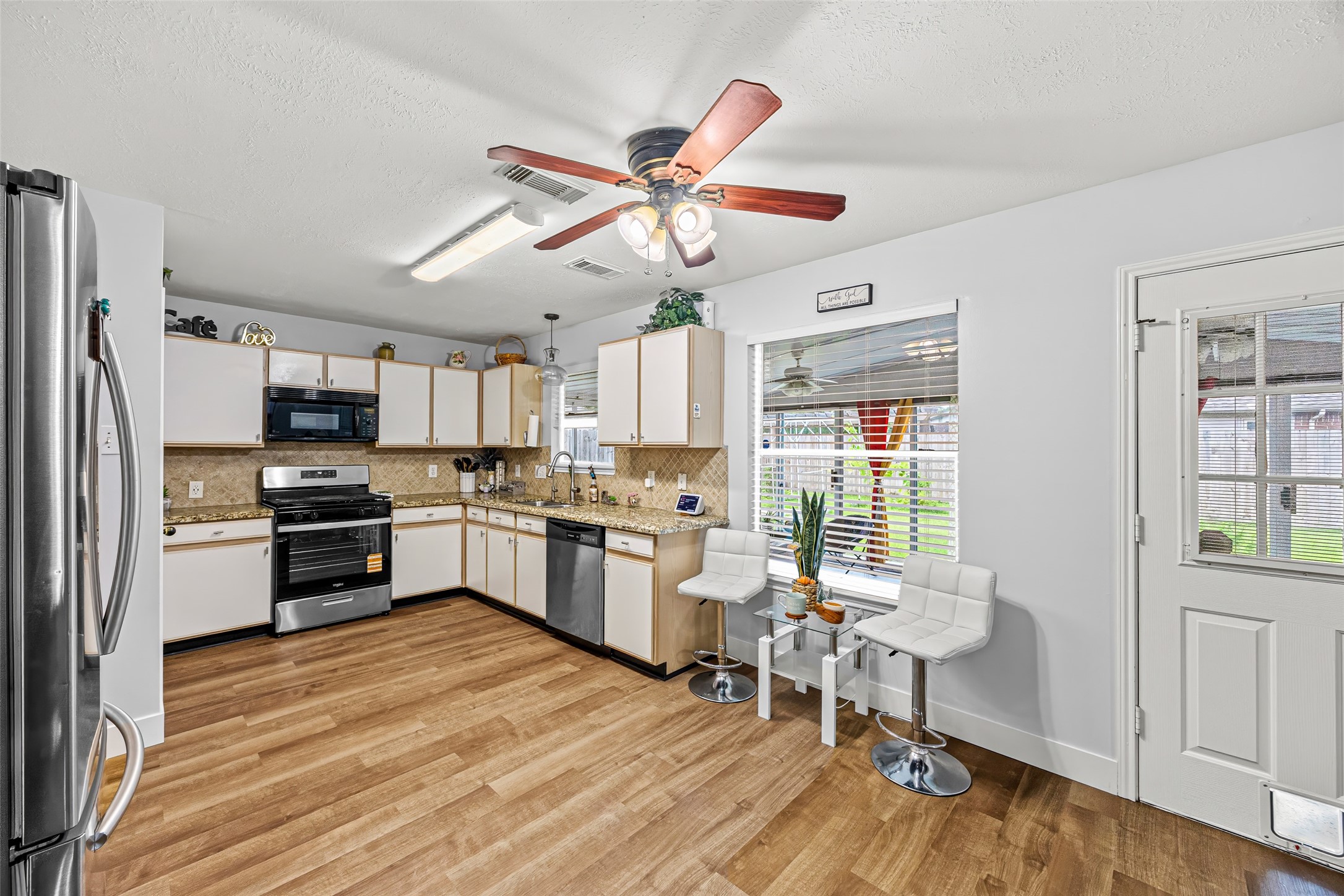 2710 Fox View Circle Spring, TX 77386 - Photo 15 of 29 a kitchen with granite countertop a stove a sink dishwasher a refrigerator and a dining table with wooden floor