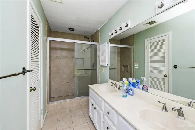 a bathroom with a double vanity sink mirror and shower