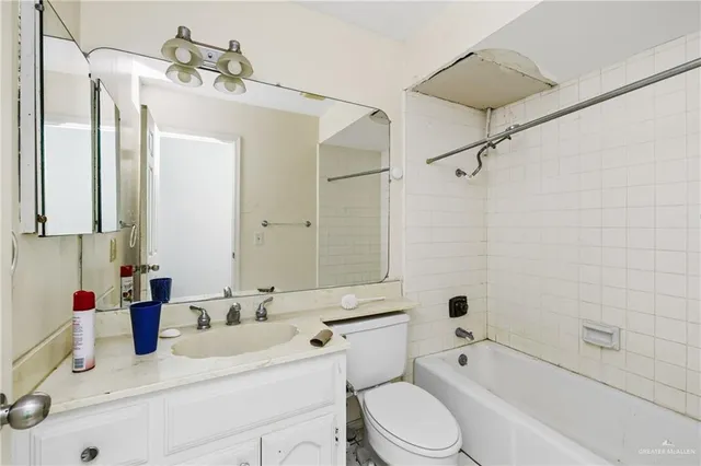 a bathroom with a sink vanity granite toilet tub and shower