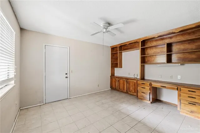 a view of an empty room with cabinet and a window
