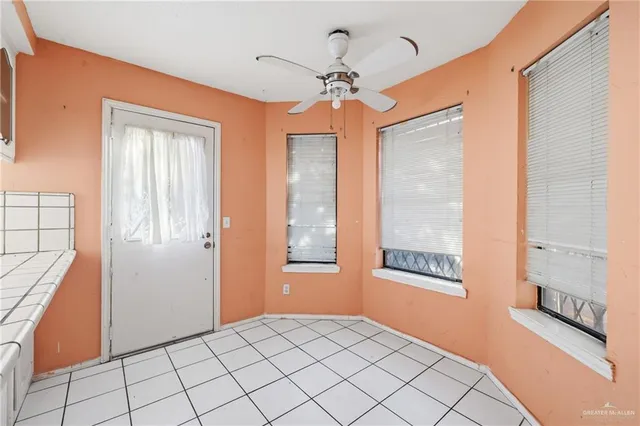 a view of an entryway with a chandelier fan and windows