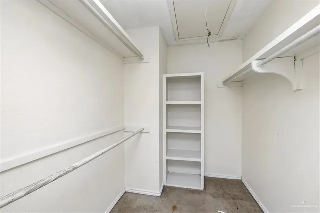 a view of walk in closet with empty racks
