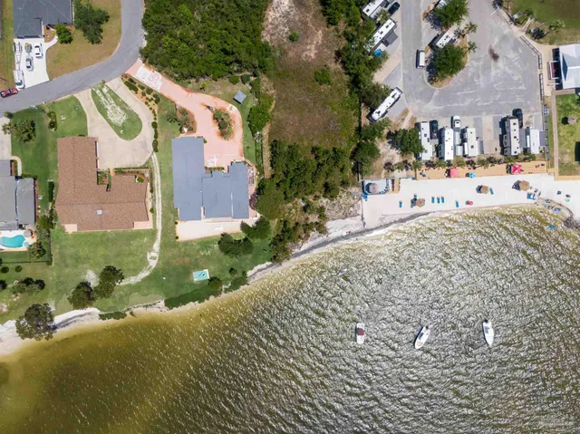 an aerial view of residential houses with outdoor space and trees