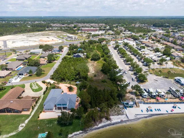 an aerial view of residential houses with outdoor space and trees