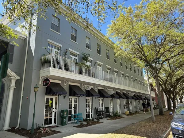 a view of a hallway with wooden floor and windows