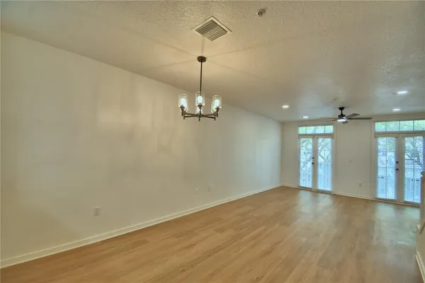 a view of a room with wooden floor chandelier and entryway