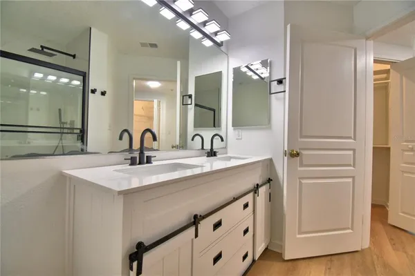 an empty room with wooden floor and ceiling fan