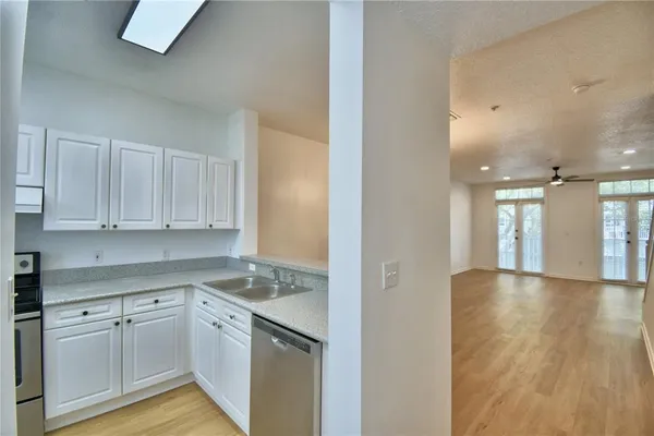 a kitchen with granite countertop white cabinets and white appliances