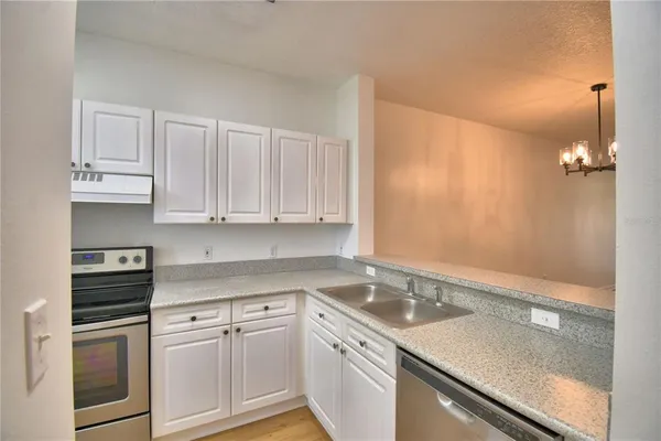 a kitchen with stainless steel appliances white cabinets and a refrigerator