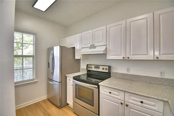 a kitchen with stainless steel appliances granite countertop a sink a stove and a refrigerator