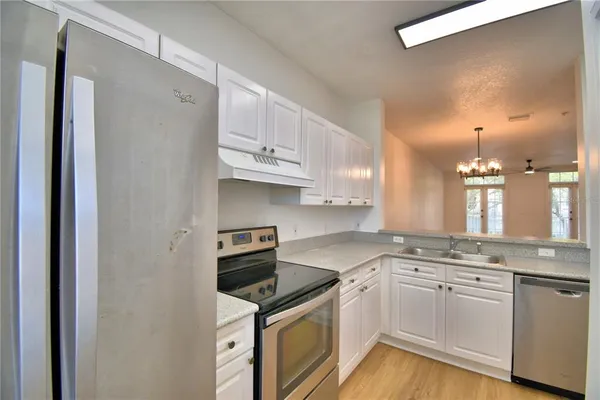 a kitchen with granite countertop white cabinets and white appliances