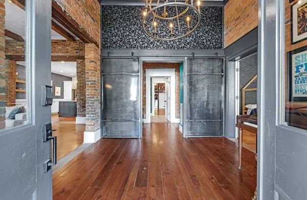 a kitchen with stainless steel appliances granite countertop a sink dishwasher and a dining table with wooden floor