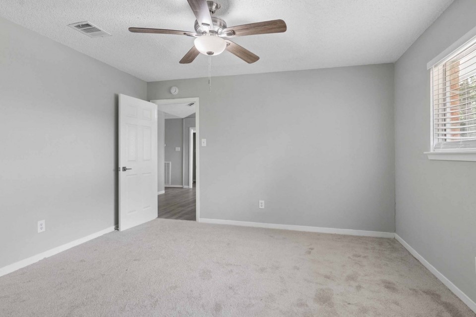 7403 Strawbridge Lane Houston, TX 77040 - Photo 13 of 22 an empty room with windows and fan