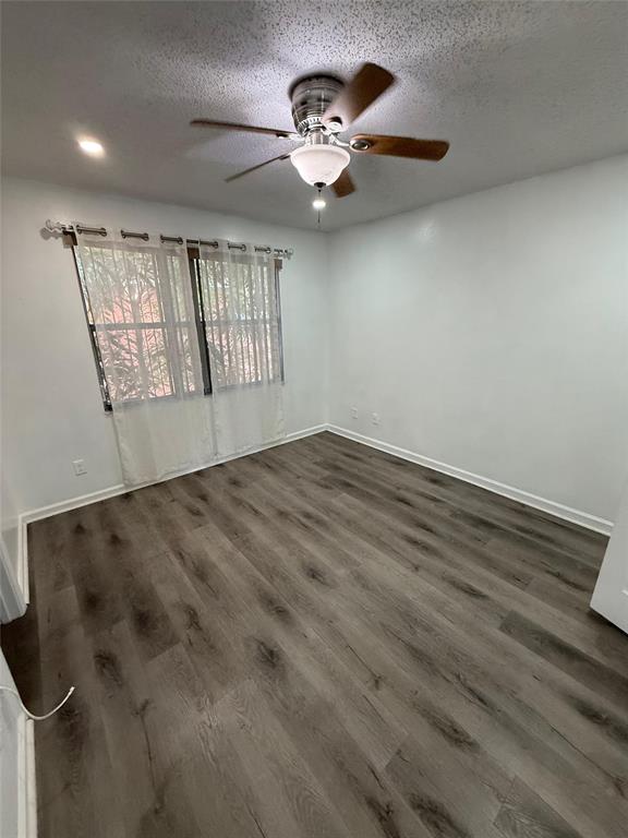 4243 Northwest 68 Way, Unit 4243 Fort Lauderdale, FL 33319 - Photo 11 of 15 an empty room with wooden floor fan and windows