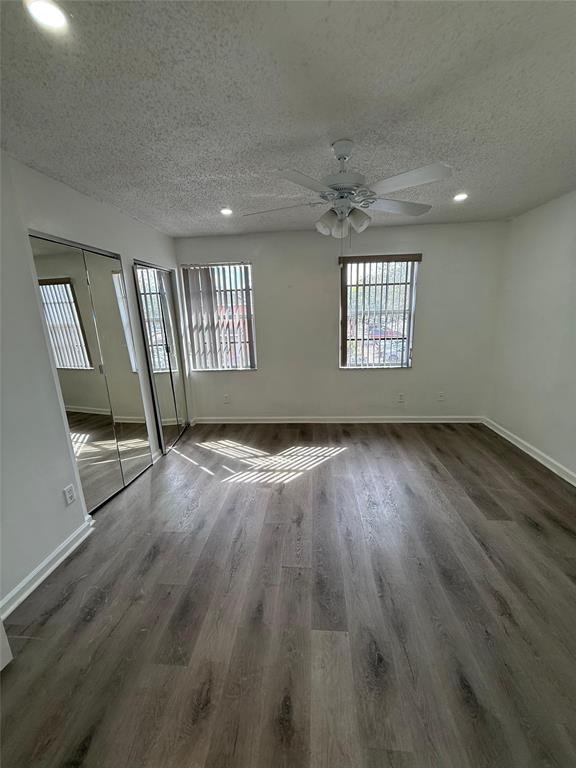 4243 Northwest 68 Way, Unit 4243 Fort Lauderdale, FL 33319 - Photo 13 of 15 an empty room with wooden floor and windows