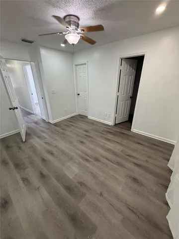 a view of an empty room with a chandelier fan