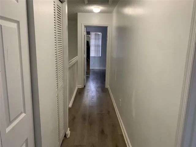 a view of a hallway with wooden floor