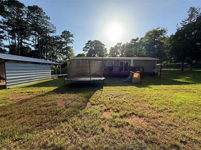 a view of a house with a yard and sitting area