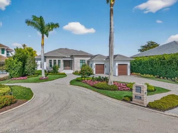 a front view of a house with a yard and potted plants