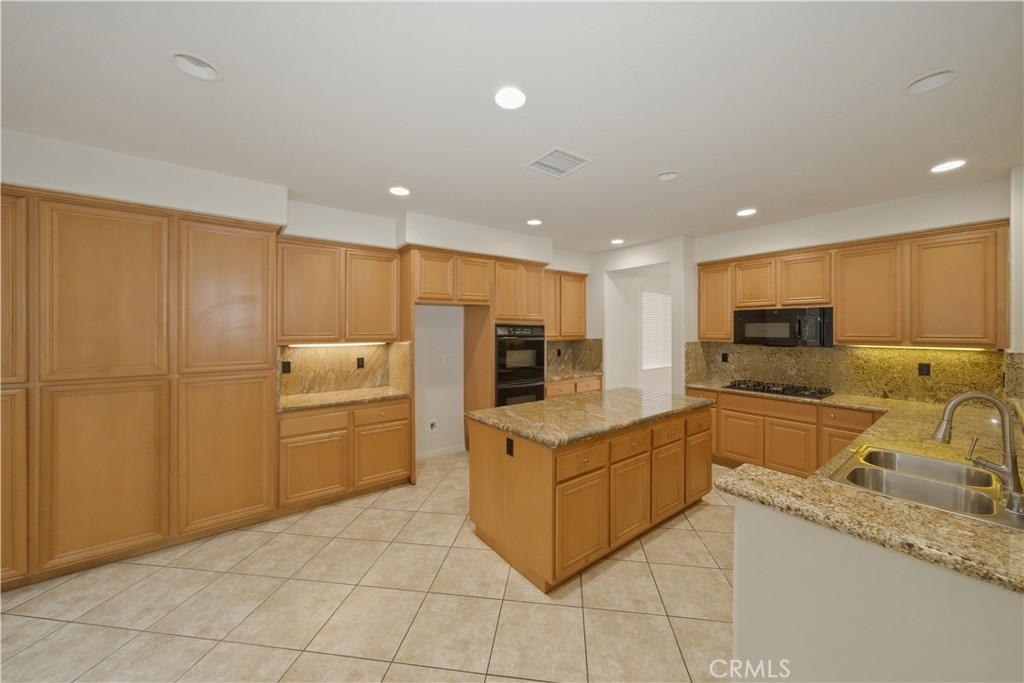 6710 Black Hawk Road Eastvale, CA 92880 - Photo 11 of 49 a kitchen with a refrigerator and a sink