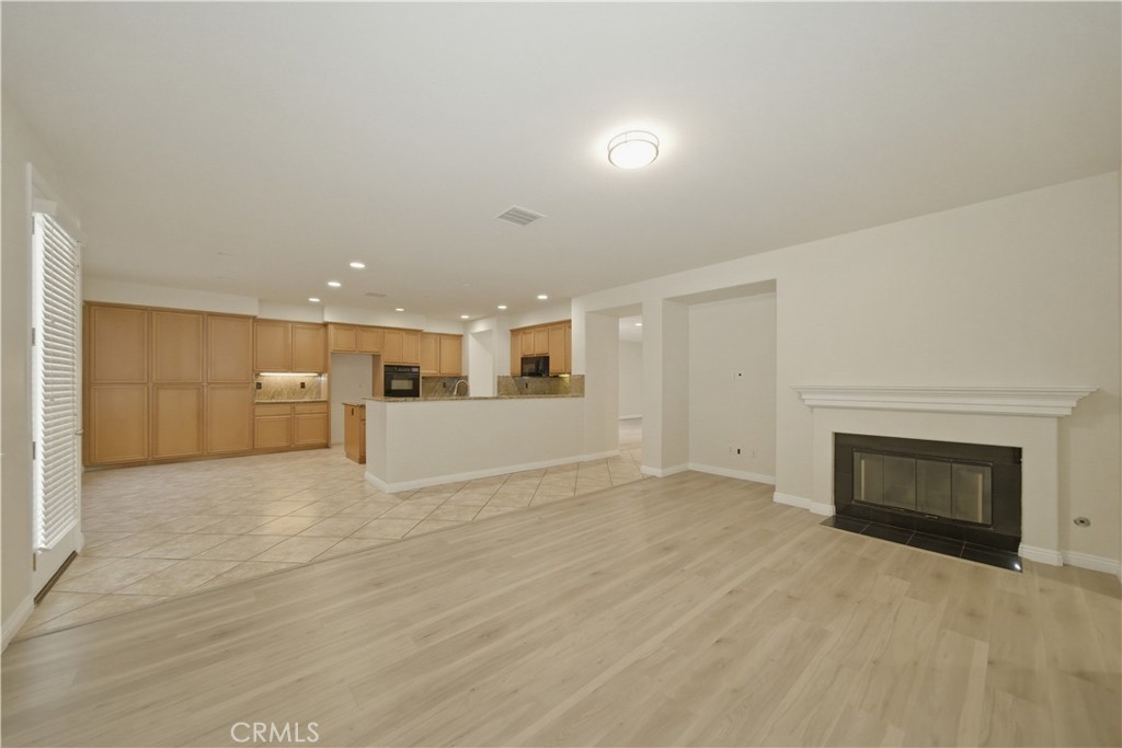 6710 Black Hawk Road Eastvale, CA 92880 - Photo 15 of 49 an empty room with kitchen and fireplace