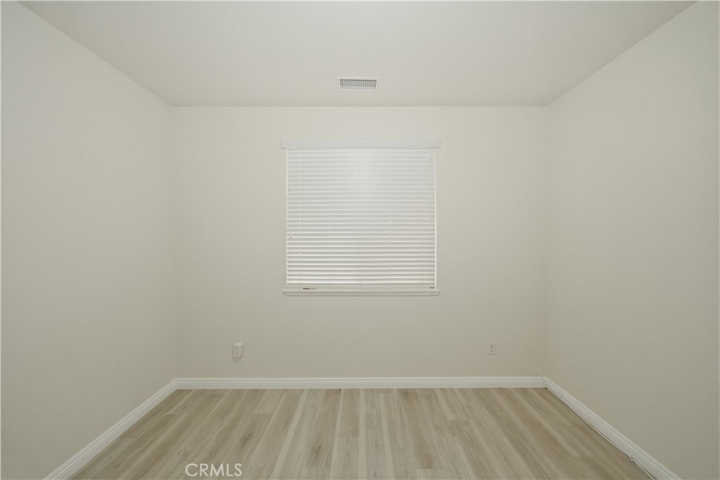 6710 Black Hawk Road Eastvale, CA 92880 - Photo 19 of 49 a view of an empty room with wooden floor and a window