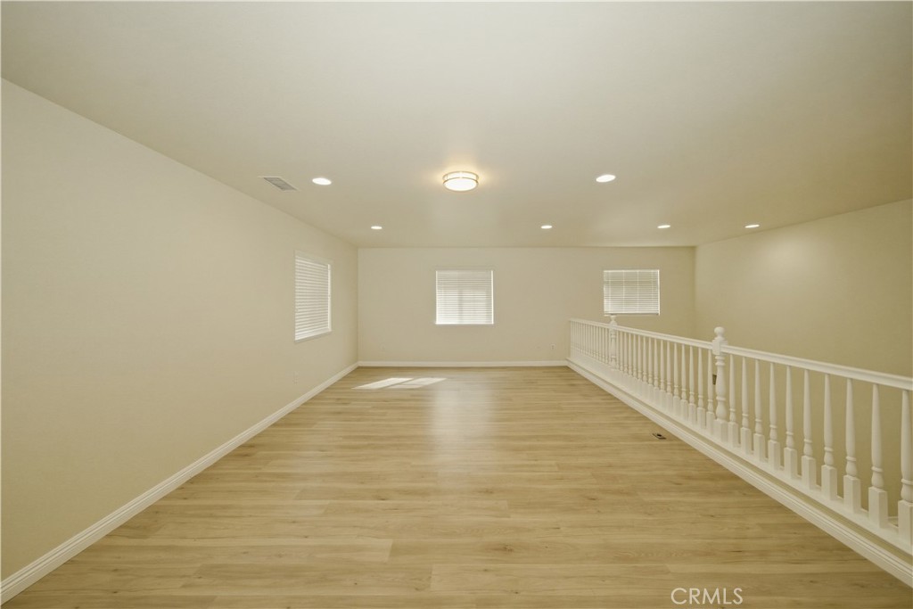 6710 Black Hawk Road Eastvale, CA 92880 - Photo 23 of 49 a view of an empty room with wooden floor and windows