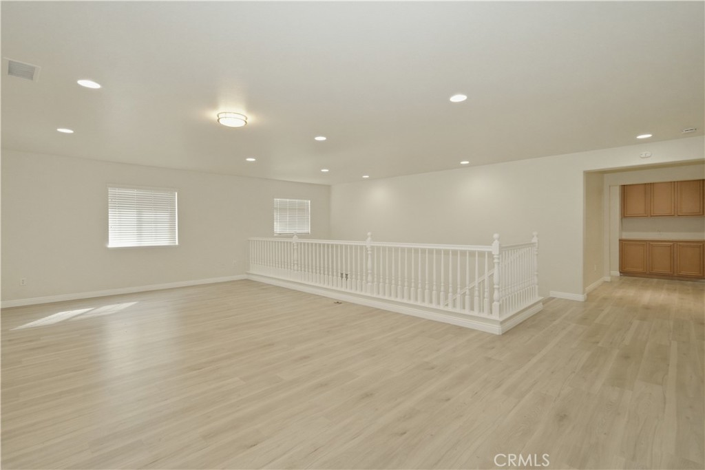 6710 Black Hawk Road Eastvale, CA 92880 - Photo 25 of 49 an empty room with wooden floor and windows
