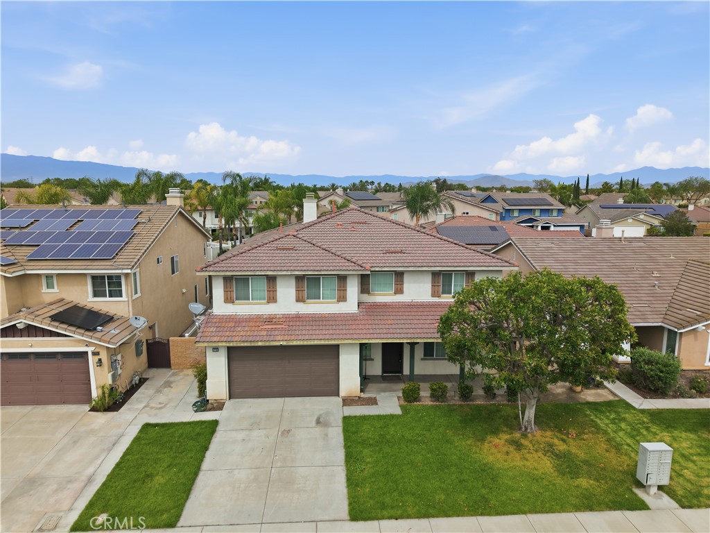 6710 Black Hawk Road Eastvale, CA 92880 - Photo 3 of 49 a front view of a house with a garden and a yard